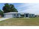 Charming light blue single-story home featuring a two-car garage, manicured lawn, and lovely landscaping at 2909 Ne 25Th St, Ocala, FL 34470