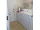 Efficient laundry room features tile floors, storage shelves, and convenient access to the exterior at 2909 Ne 25Th St, Ocala, FL 34470