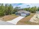 Beautiful exterior view of a gray single-Gathering home, surrounded by lush greenery, features a long driveway at 400 Mariion Oaks Crse, Ocala, FL 34473