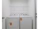 A well-lit laundry room area with a washer, dryer, and wire rack shelving at 400 Mariion Oaks Crse, Ocala, FL 34473