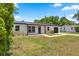 Charming single-story home featuring a dark metal roof, bright white siding, and an attached garage with a well-kept lawn at 4095 Sw 144Th St, Ocala, FL 34473
