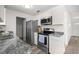 Modern kitchen with stainless steel appliances, granite countertops, and white cabinets at 4095 Sw 144Th St, Ocala, FL 34473