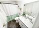 Well-lit bathroom with a shower featuring a green and white curtain, and modern fixtures at 5263 Nw 62Nd Nw Ave, Ocala, FL 34482