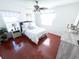 Cozy bedroom with hardwood floors, a ceiling fan, and a comfortable bed with plenty of pillows at 5263 Nw 62Nd Nw Ave, Ocala, FL 34482