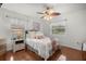 Bright bedroom with wood floors, ceiling fan, and a plush bed complemented by natural light from two windows at 5263 Nw 62Nd Nw Ave, Ocala, FL 34482