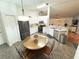 Bright kitchen featuring white cabinets, black appliances, and a cozy dining area under a modern light fixture at 5263 Nw 62Nd Nw Ave, Ocala, FL 34482