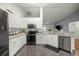 Bright kitchen featuring white cabinetry, stainless steel appliances, stone flooring, and open floor plan at 5263 Nw 62Nd Nw Ave, Ocala, FL 34482