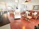 Open-concept living room with hardwood floors, a leather sofa, and a view of the kitchen at 5263 Nw 62Nd Nw Ave, Ocala, FL 34482