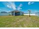 Large backyard with a lush lawn, white fence, and screened-in lanai, perfect for outdoor activities at 5621 Sw 90Th Ln, Ocala, FL 34476