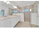 Bright bathroom showcasing a double sink vanity and a glass-enclosed shower at 5621 Sw 90Th Ln, Ocala, FL 34476