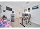 Bright flex room includes neutral decor, a futon, desk, monitor setup, and mini-fridge at 5621 Sw 90Th Ln, Ocala, FL 34476