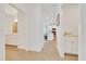Bright hallway offering a glimpse into the kitchen and two bathrooms featuring tile floors and white cabinets at 5621 Sw 90Th Ln, Ocala, FL 34476