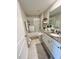 Comfortable bathroom with granite countertops, a large mirror, and a shower-tub, and decorative shelving at 5667 Sw 92Nd Pl, Ocala, FL 34476
