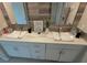 Bathroom vanity with double sinks, white cabinetry, and modern fixtures, complemented by stylish mirrors and decor at 5667 Sw 92Nd Pl, Ocala, FL 34476