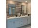 Bathroom vanity with double sinks, white cabinetry, and modern fixtures, complemented by stylish mirrors and decor at 5667 Sw 92Nd Pl, Ocala, FL 34476