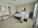 A bright bedroom with light wood floors, a queen-sized bed, and neutral-toned walls at 5667 Sw 92Nd Pl, Ocala, FL 34476