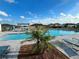 Community pool featuring lounge chairs, pergola, and well-maintained landscaping under a sunny sky at 5667 Sw 92Nd Pl, Ocala, FL 34476