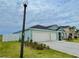 This blue home features a two-car garage and well-maintained landscaping, located on a spacious lot at 5667 Sw 92Nd Pl, Ocala, FL 34476