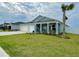 Beautiful blue home with a well-manicured lawn, covered porch, and a two-car garage, perfect for families at 5667 Sw 92Nd Pl, Ocala, FL 34476