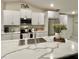 Modern kitchen features white cabinets, stainless steel appliances, and a large center island with quartz countertop at 5667 Sw 92Nd Pl, Ocala, FL 34476
