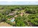 Aerial view of a property with mature trees, pool and detached sheds, offering privacy and a sense of seclusion at 6157 Ne 25Th Ave, Ocala, FL 34479