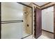 Shower with glass doors, tiled walls, and updated fixtures next to bathroom door at 6157 Ne 25Th Ave, Ocala, FL 34479