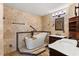 The elegant bathroom includes a soaking tub, dual vanities, and stone tile at 6157 Ne 25Th Ave, Ocala, FL 34479