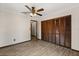 Bedroom features wood-look floors, ceiling fan, and ample closet space with shutter doors at 6157 Ne 25Th Ave, Ocala, FL 34479