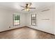 Bright bedroom with wood-look floors, ceiling fan, and natural light from two windows at 6157 Ne 25Th Ave, Ocala, FL 34479
