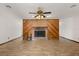 Open living room featuring a brick fireplace with wood accents and tile flooring at 6157 Ne 25Th Ave, Ocala, FL 34479
