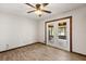 This living room includes wood-look tile flooring, neutral walls, ceiling fan, and glass doors at 6157 Ne 25Th Ave, Ocala, FL 34479
