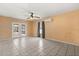 Spacious living room with tile flooring, ceiling fan, and access to the screened-in patio at 6157 Ne 25Th Ave, Ocala, FL 34479