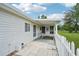 Covered back patio featuring tiled flooring, a white picket fence, and a peaceful outdoor setting at 6448 Sw 111Th Pl, Ocala, FL 34476