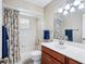 Well-lit bathroom features a shower-tub combination, neutral tile, and wood-tone vanity with white countertop at 6448 Sw 111Th Pl, Ocala, FL 34476