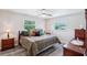 Comfortable bedroom with ceiling fan, wood-look flooring, and natural light from two windows at 6448 Sw 111Th Pl, Ocala, FL 34476