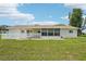 Back exterior view of home featuring large screened-in porch, back patio, and well-maintained lawn at 6448 Sw 111Th Pl, Ocala, FL 34476
