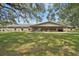 Expansive brick building with large covered patio and lush lawn, perfect for outdoor entertaining at 6448 Sw 111Th Pl, Ocala, FL 34476