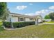 Inviting single-story home showcasing a well-kept lawn, decorative landscaping, and a classic facade with red shutters at 6448 Sw 111Th Pl, Ocala, FL 34476