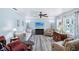 Bright and inviting living room featuring laminate floors, a ceiling fan, and large windows at 6448 Sw 111Th Pl, Ocala, FL 34476
