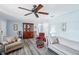 Cozy living room featuring updated laminate flooring, neutral paint, ceiling fan, and comfortable furnishings at 6448 Sw 111Th Pl, Ocala, FL 34476