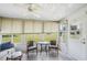 Sunroom features neutral color palette, ceiling fan, tile flooring, large windows, and outdoor views at 6448 Sw 111Th Pl, Ocala, FL 34476