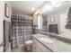 Neutral bathroom with a granite countertop and shower with grey, ruffled curtain at 7 Larch Dr, Ocala, FL 34480