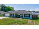 Charming home featuring a well-maintained lawn, classic windows with shutters, and an attached garage at 7 Larch Dr, Ocala, FL 34480