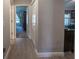 Hallway view that reveals neutral paint, a glimpse of a bedroom, and vinyl flooring at 7 Larch Dr, Ocala, FL 34480