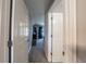 Hallway with white doors and carpet flooring leading to the living area at 7 Larch Dr, Ocala, FL 34480