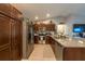 Spacious kitchen featuring stainless steel appliances, dark wood cabinetry, and granite countertops and decor at 7 Larch Dr, Ocala, FL 34480