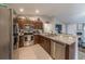 Well-equipped kitchen with granite countertops, stainless steel appliances, and dark wood cabinets and decor at 7 Larch Dr, Ocala, FL 34480