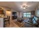 Cozy living room featuring a leather sofa, TV, and ceiling fan at 7 Larch Dr, Ocala, FL 34480