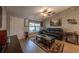 Cozy living room with a black leather sofa, ceiling fan, and a glass-top coffee table on a decorative rug at 7 Larch Dr, Ocala, FL 34480