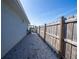 View of gravel side yard between house and wood fence, showing a narrow walkway at 7 Larch Dr, Ocala, FL 34480